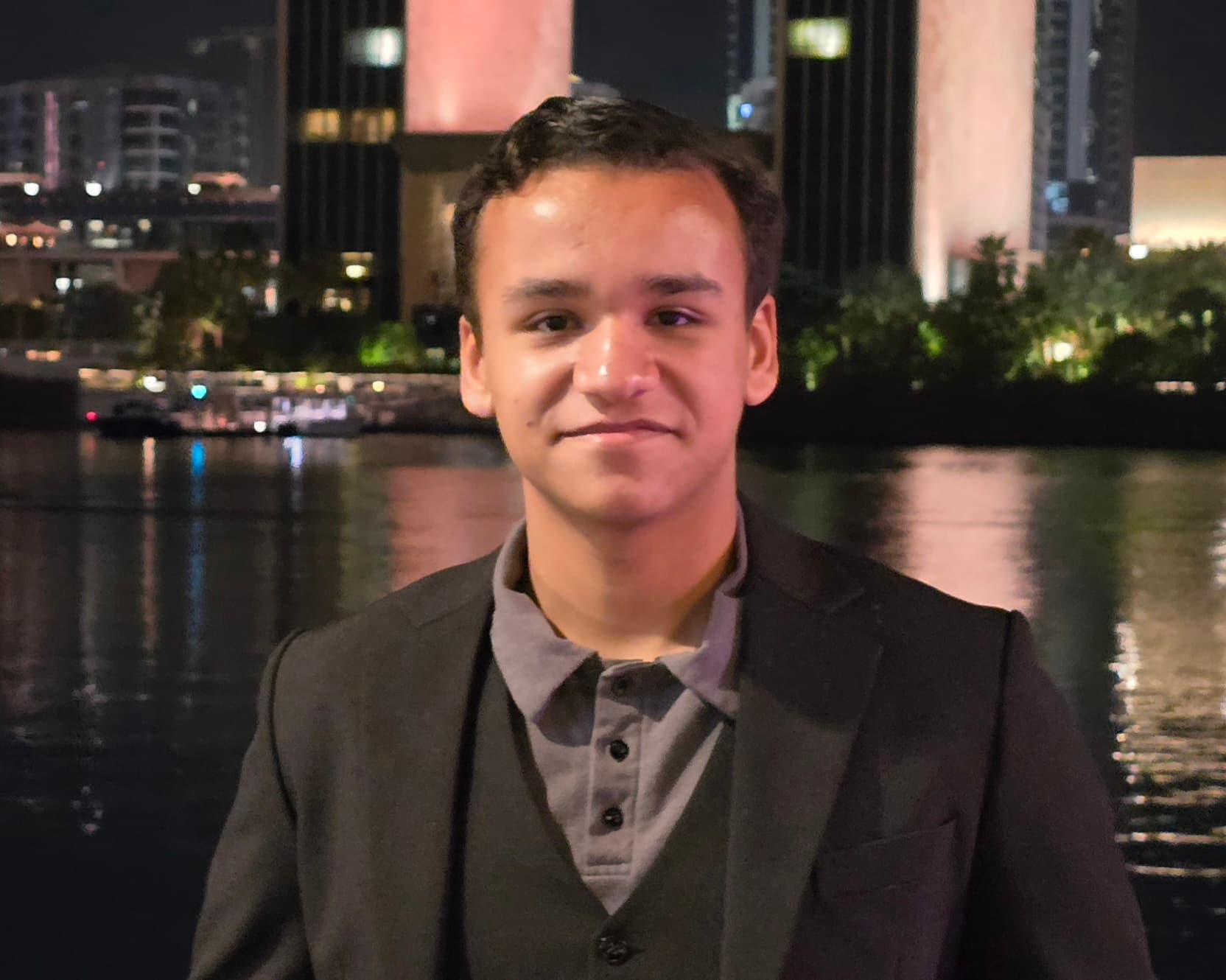 Yaseen A. Naser, known as Rajallah, wearing a suit in front of the Four Seasons Hotel Bahrain Bay.